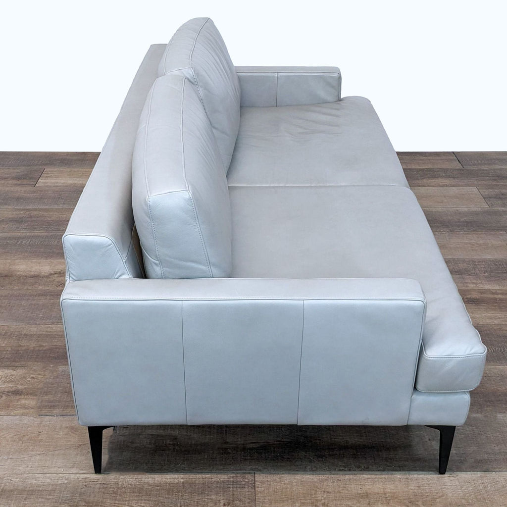 2. Side perspective of a 3-seat West Elm Andes leather sofa with modern style, highlighting the armrest and metal leg support.