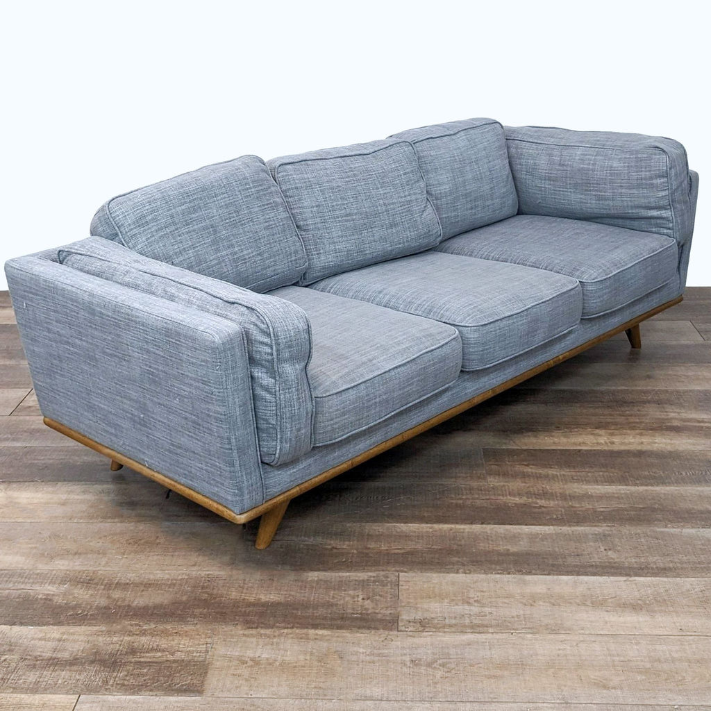 Light blue textured linen upholstered 3-seat sofa with a Mid-Century Modern design by Article, shown in an interior setting.