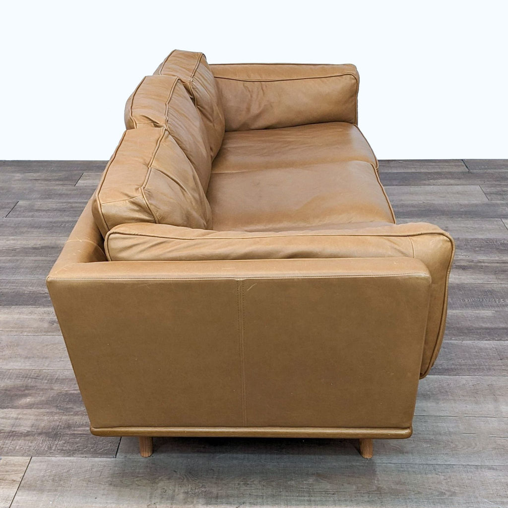 Front view of a 3-seat Article Timber sofa, featuring mid-century style and upholstered in Charme Tan leather.