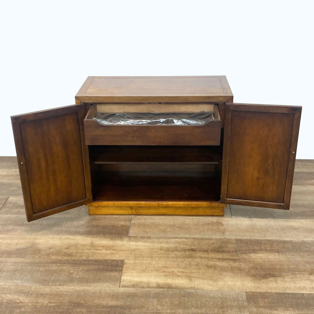 Open Henredon credenza displaying interior with a dove-tailed drawer with silver holder in plastic and a shelf.