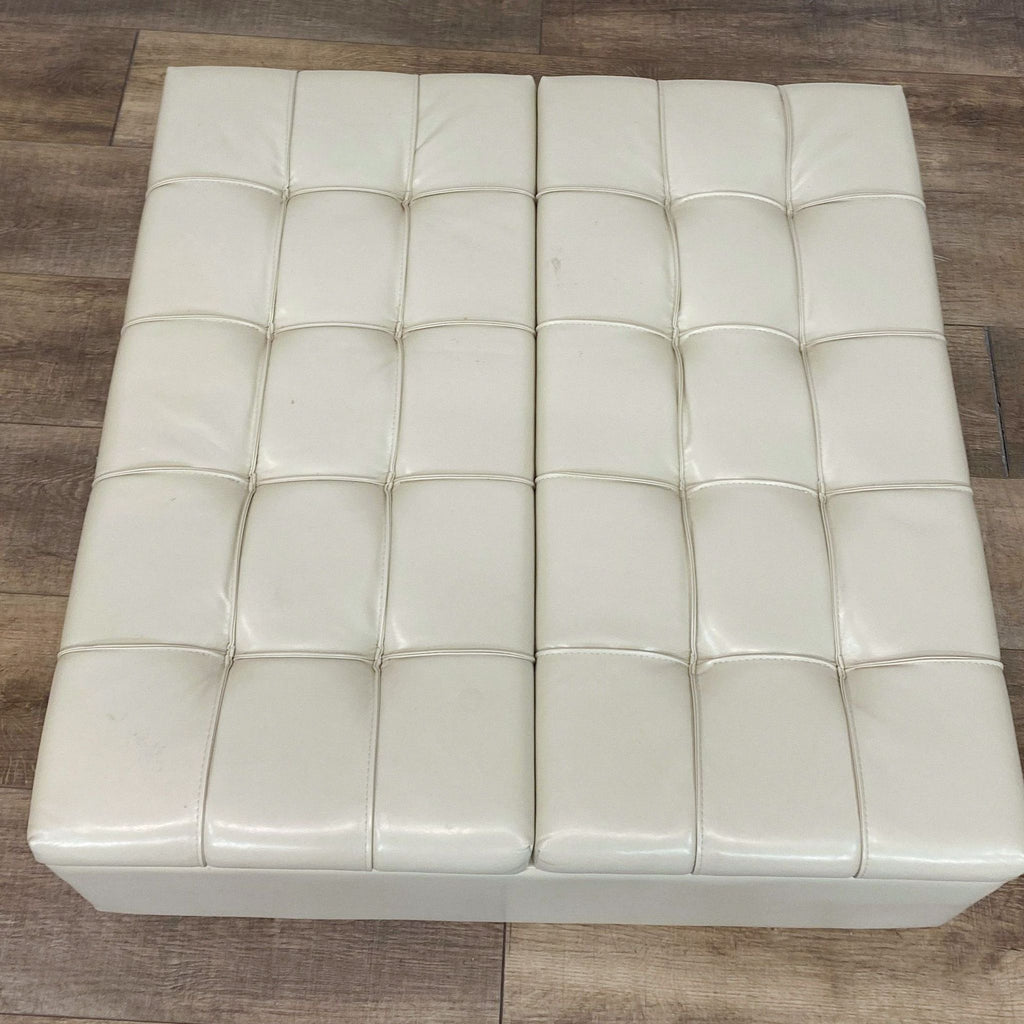 3. Reperch brand ivory tufted storage ottoman viewed from top, on wooden floor.