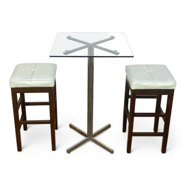 1. Reperch glass-top dining table with X-shaped metal base and two faux leather stools on a white background.