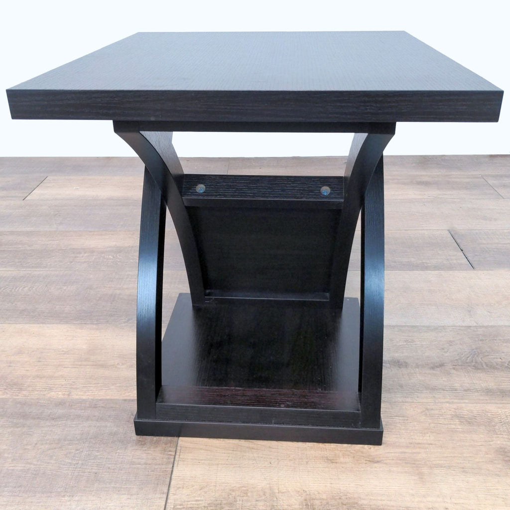 Contemporary black end table by Wayfair with sleek silhouette on wooden floor.