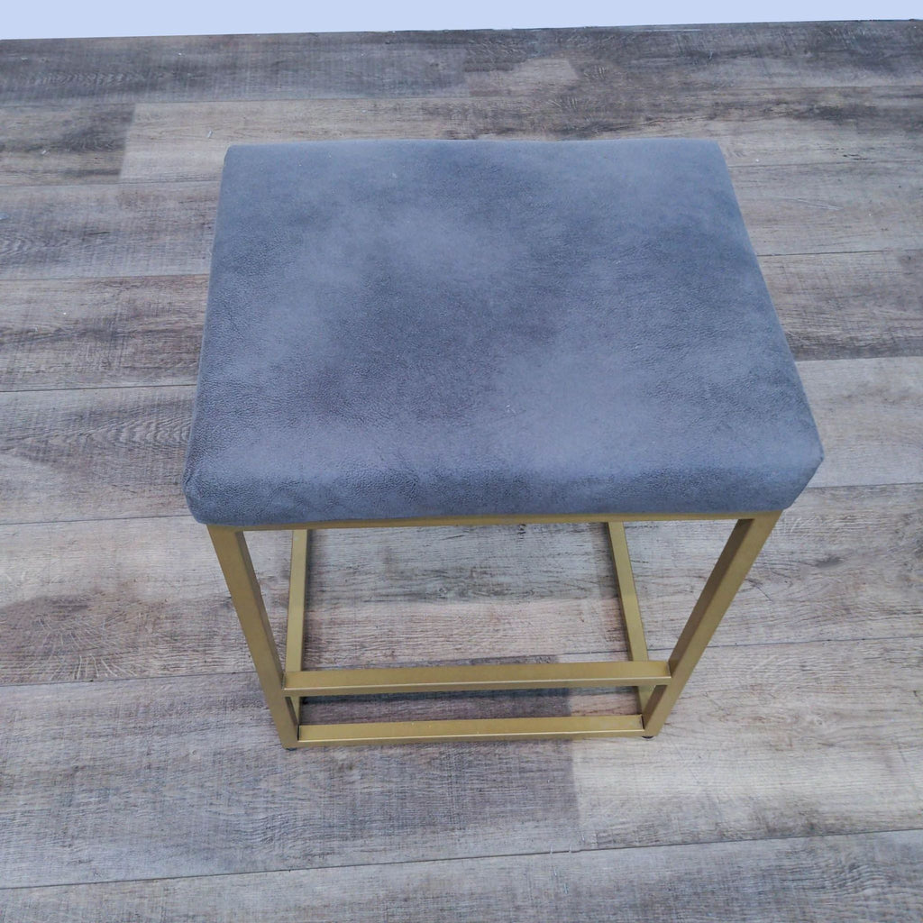 Modern Reperch stool featuring a simple line design, grey seat cushion without backrest on a gold frame.