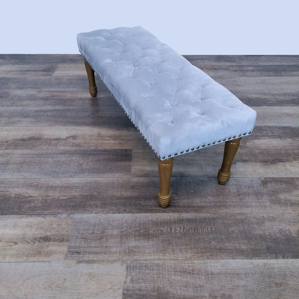 2. Rectangular grey upholstered bench with button tufting and nailhead accents on solid wood legs by Reperch.