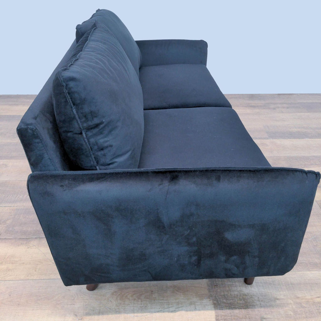 Velvet loveseat from Reperch, featuring wooden legs.