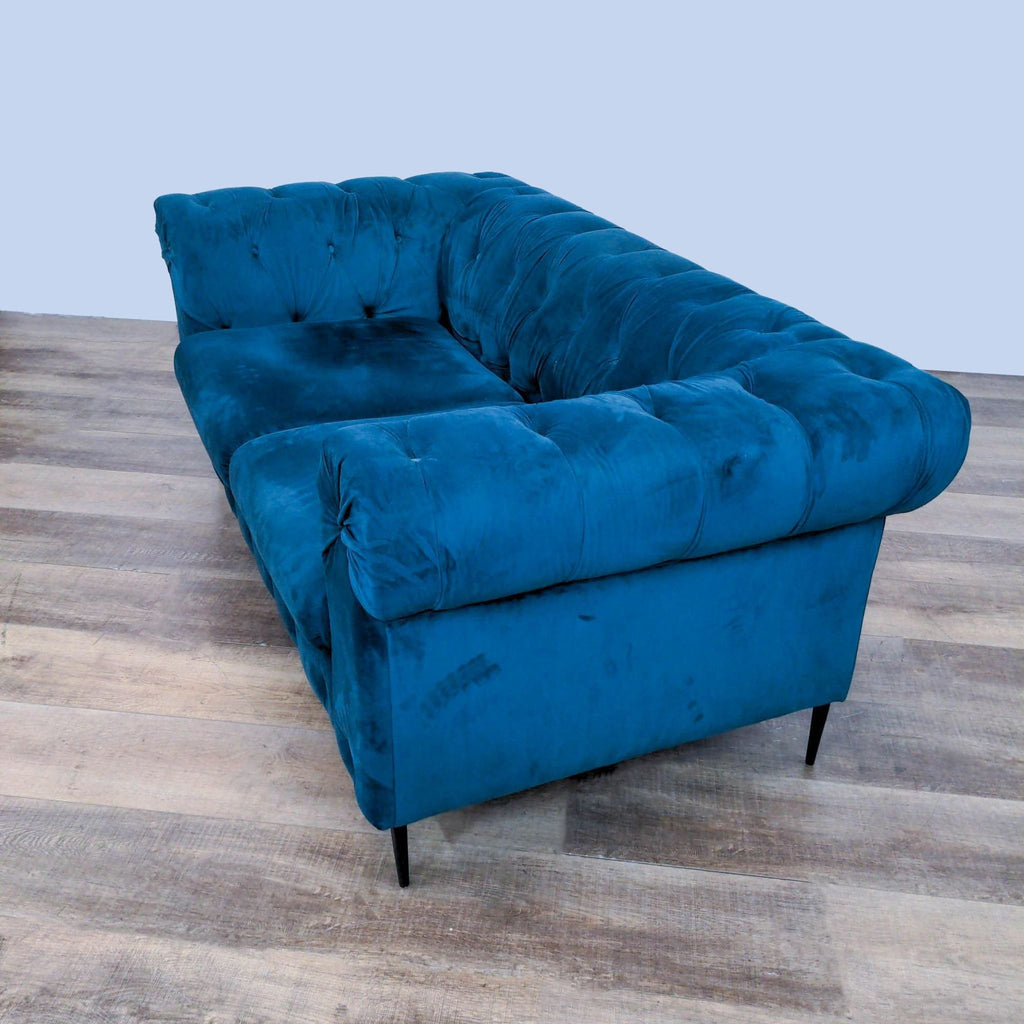 2. "Side angle of a contemporary Reperch blue velvet loveseat, highlighting the plush tufting and sturdy legs."