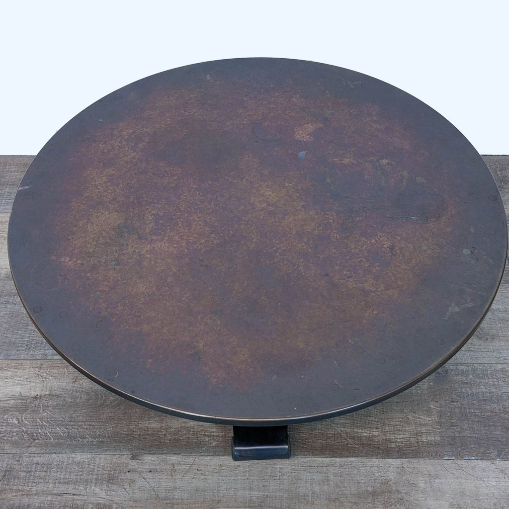 2. Top view of a round copper-topped coffee table by Crate & Barrel, emphasizing the textured surface.