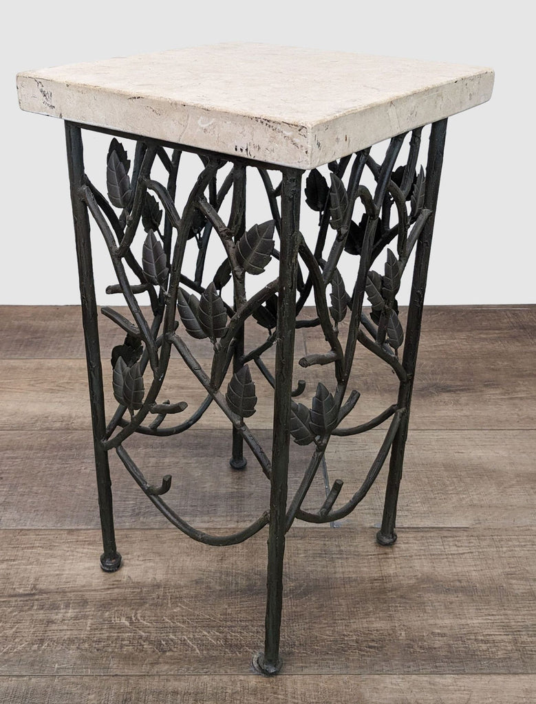 Reperch brand square table showcasing a stone top and intricate ironwork with leaves on a white background.