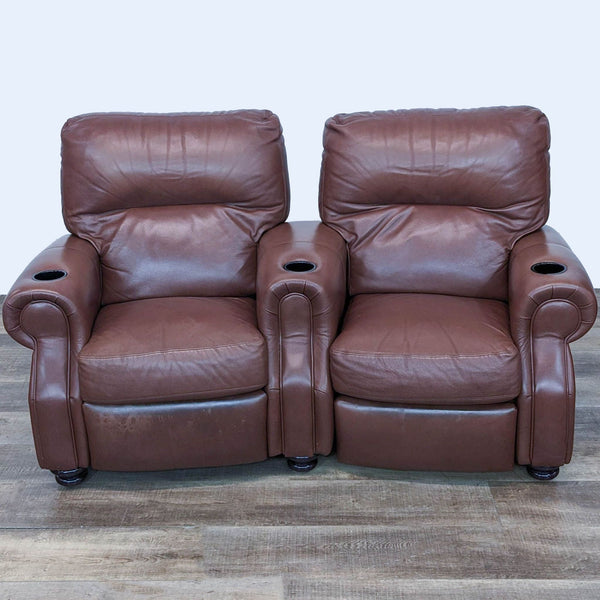 1. Front view of a pair of Reperch leather reclining seats with plush cushioning and built-in cup holders on a wooden floor.