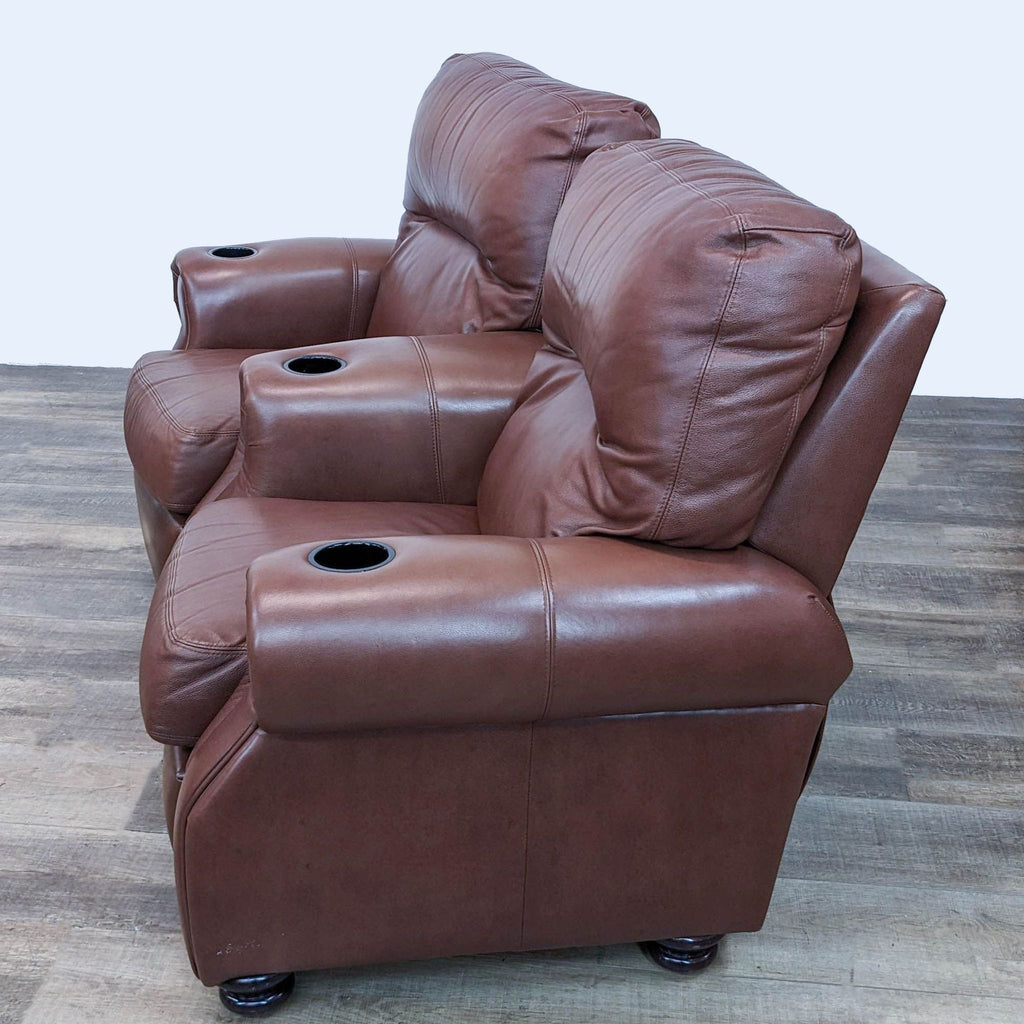 2. Side perspective of two Reperch brown leather reclining lounge seats, showcasing their comfortable design and cup holders.
