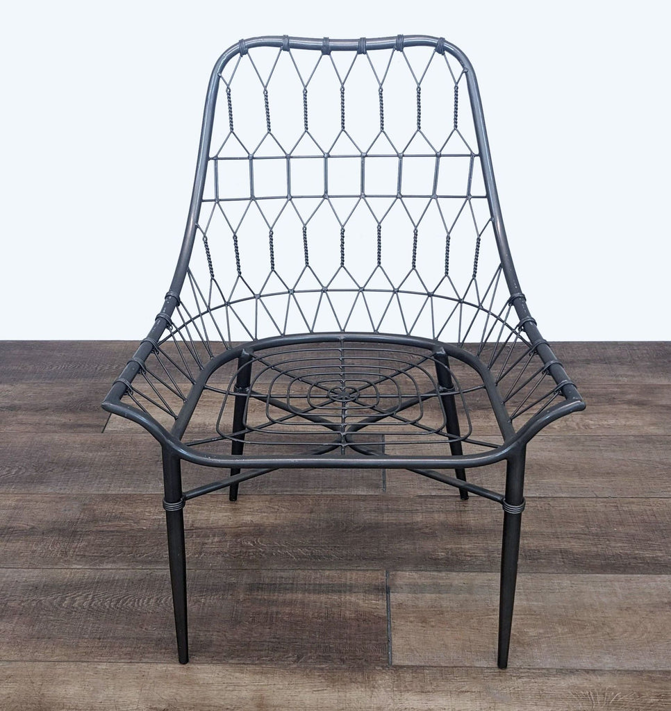 Reperch modern dining chair with a black iron open weave design, standing on a wooden floor.