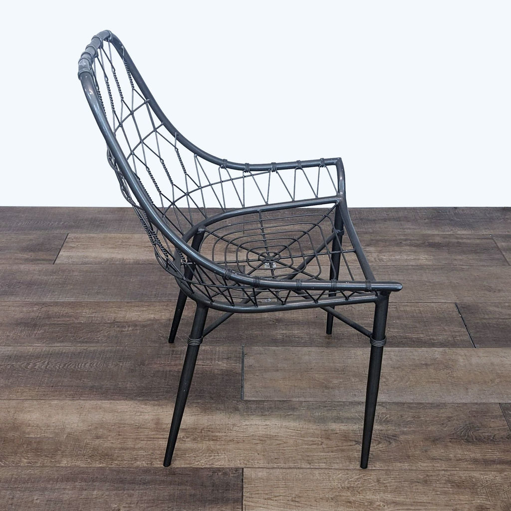 Angled view of a Reperch indoor/outdoor chair featuring a unique iron lattice work on a wooden surface.