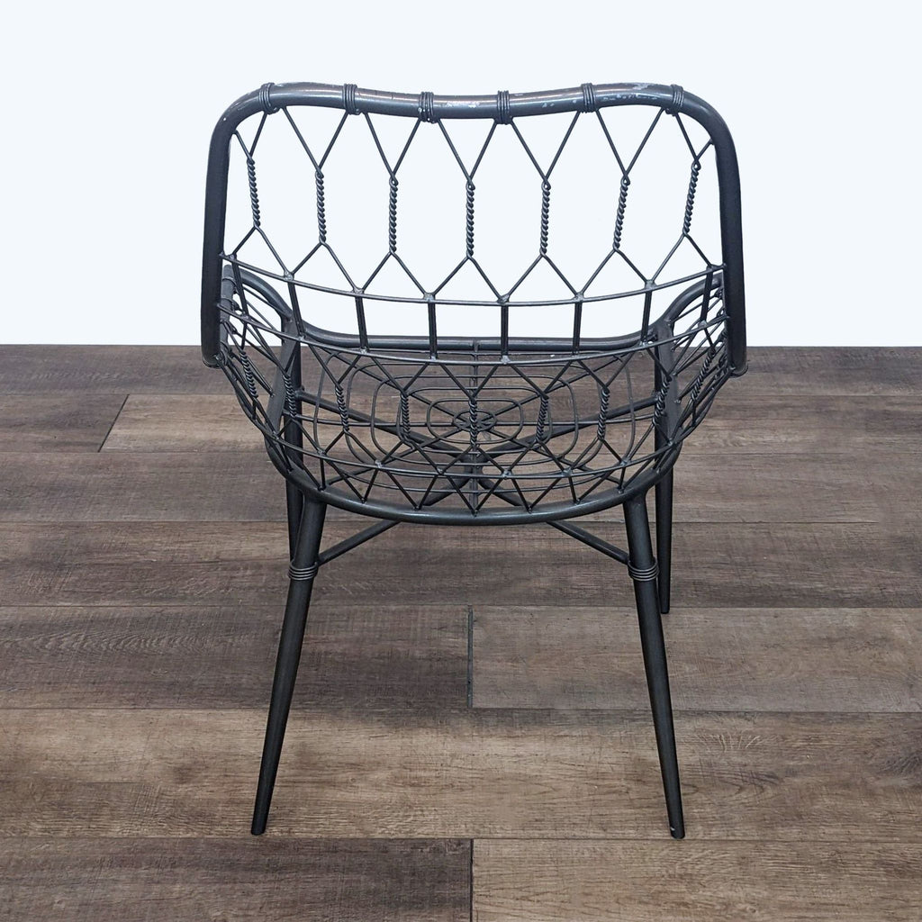 Back view of a Reperch dining chair with intricate iron weaving, showcasing its modern rattan twist.