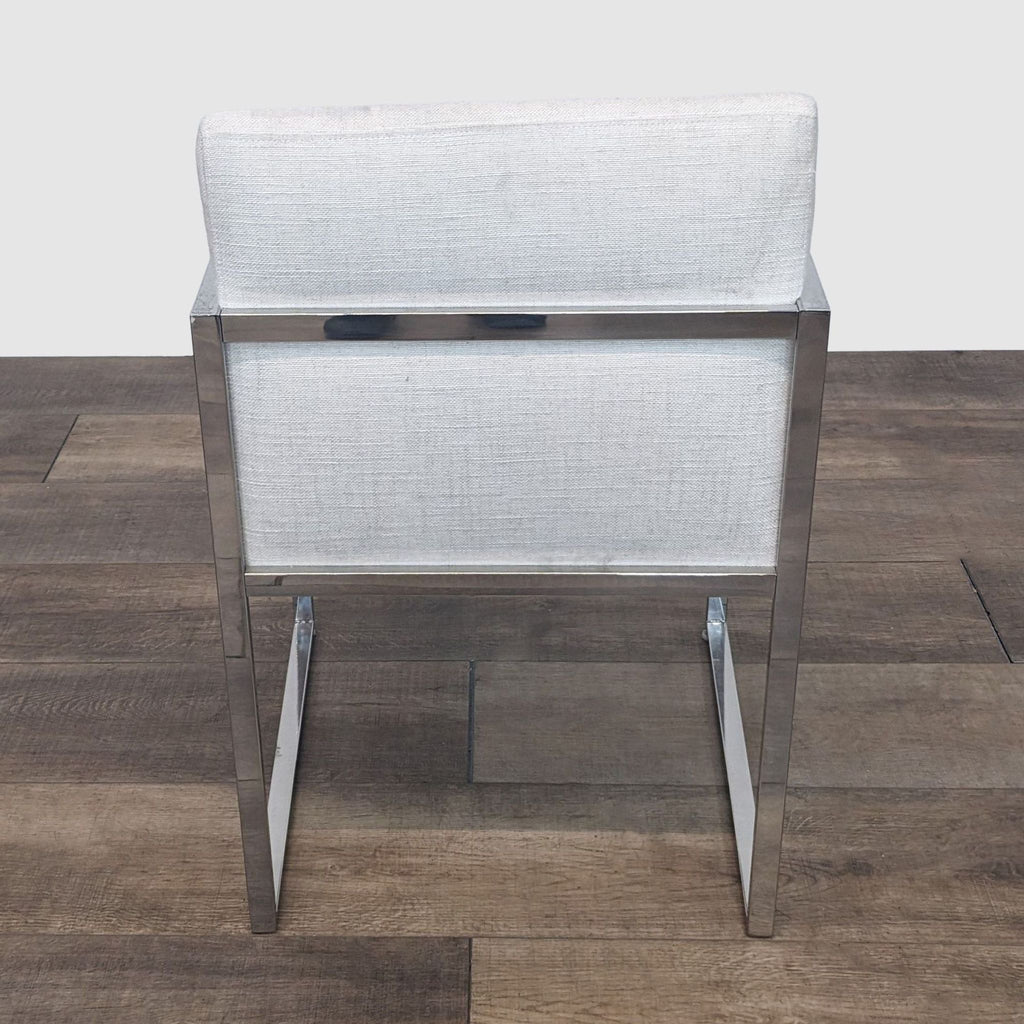 Reperch dining chair showcasing its linen back and sturdy metal frame from behind.
