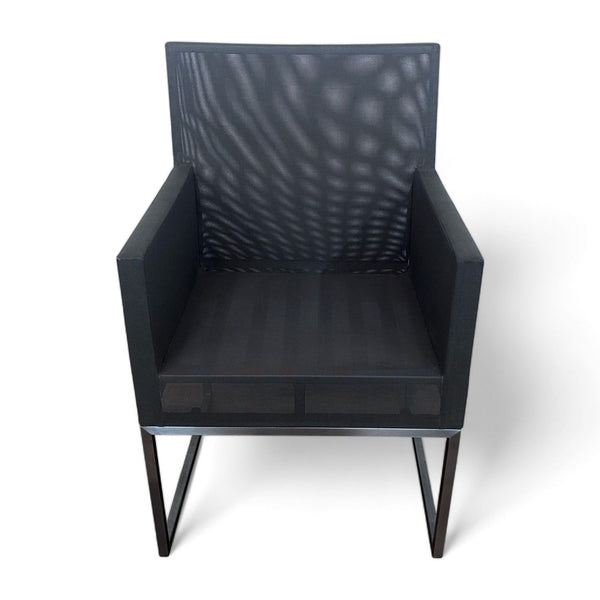 Crate & Barrel modern outdoor dining armchair with black mesh fabric and aluminum frame.
