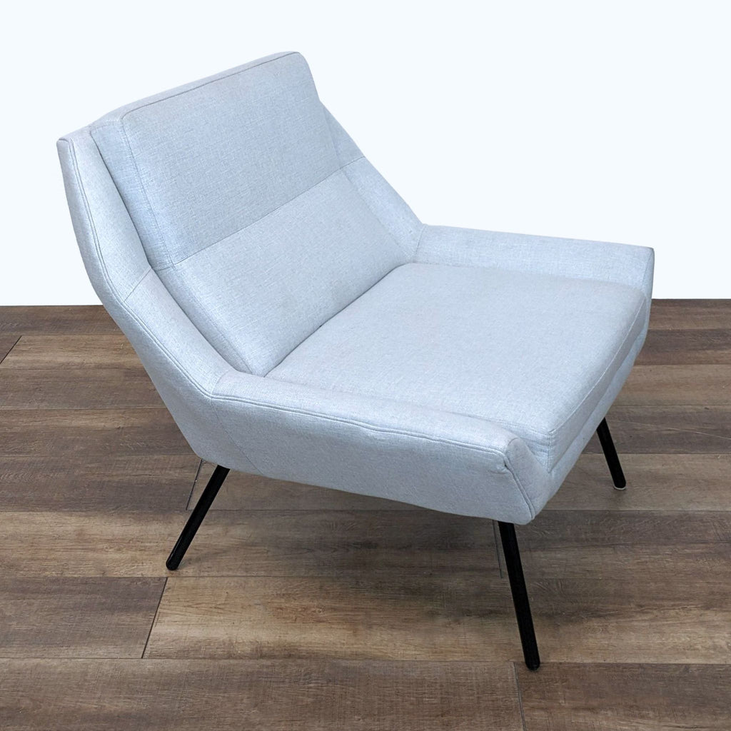 3. "Side view of a contemporary light grey Z Chair by HD Buttercup, with well-defined seat and back padding, set on slim black metal legs."