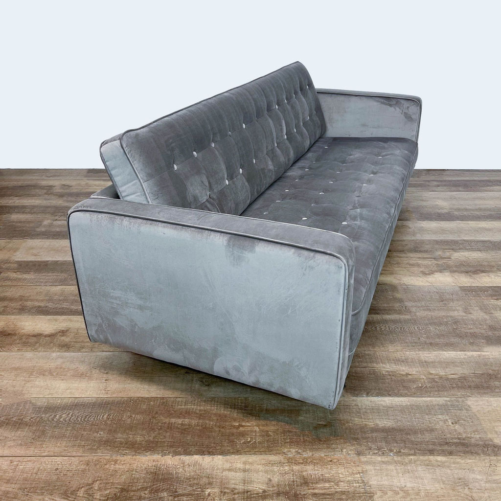 2. Side-angle view of a gray Juniper sofa by Diamond Sofa, highlighting its clean lines, tufted velvet fabric, and wooden legs.