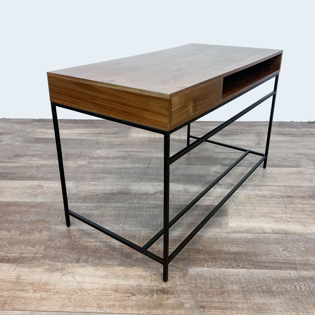 2. Angled view of a stylish Living Spaces desk showing the wood finish, open shelf space, and black metal legs.