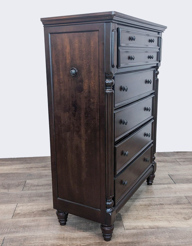 Side angle of a traditional style Ashley Signature wooden dresser with visible side paneling and brass knobs.