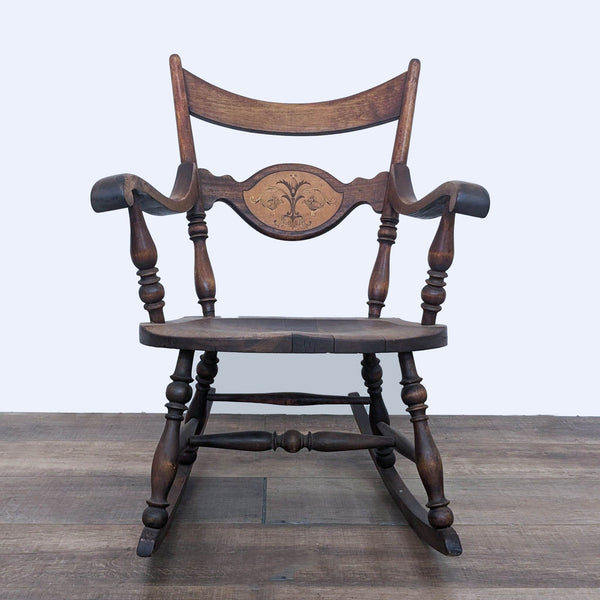 Reperch antique wooden rocking chair with floral inlay and spindle details, front view.