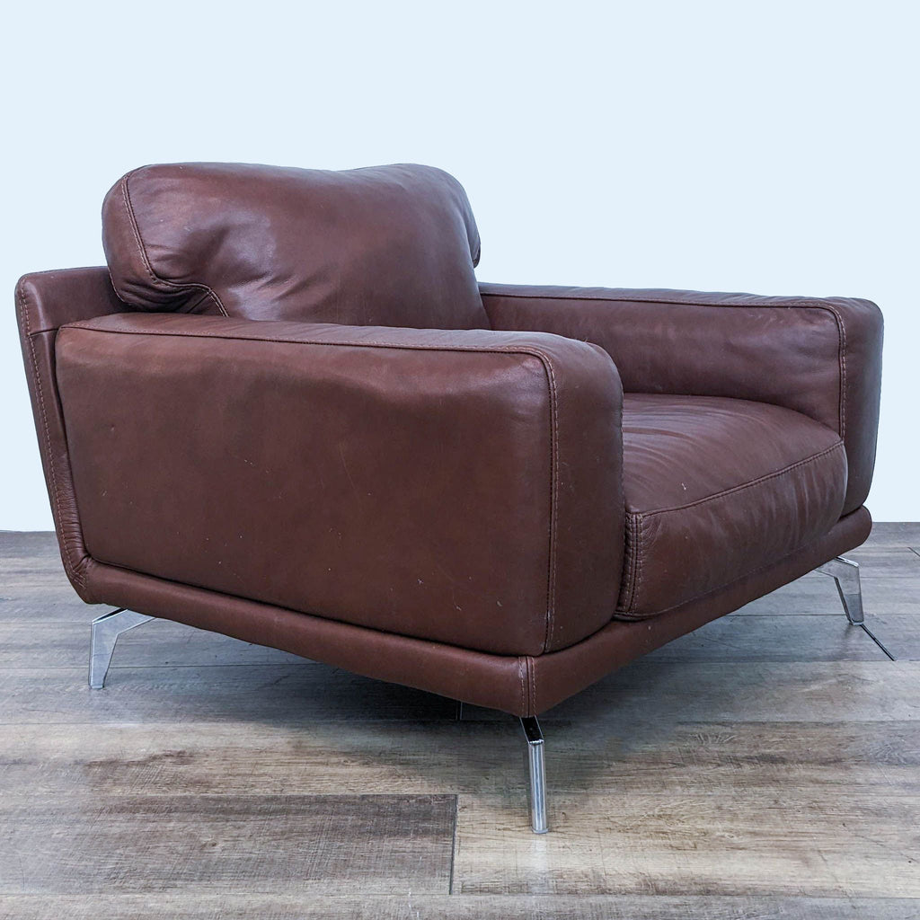 2. Side angle of a Scandinavian Designs Peruna lounge chair showcasing the wide arms and overstuffed cushions in cognac leather.