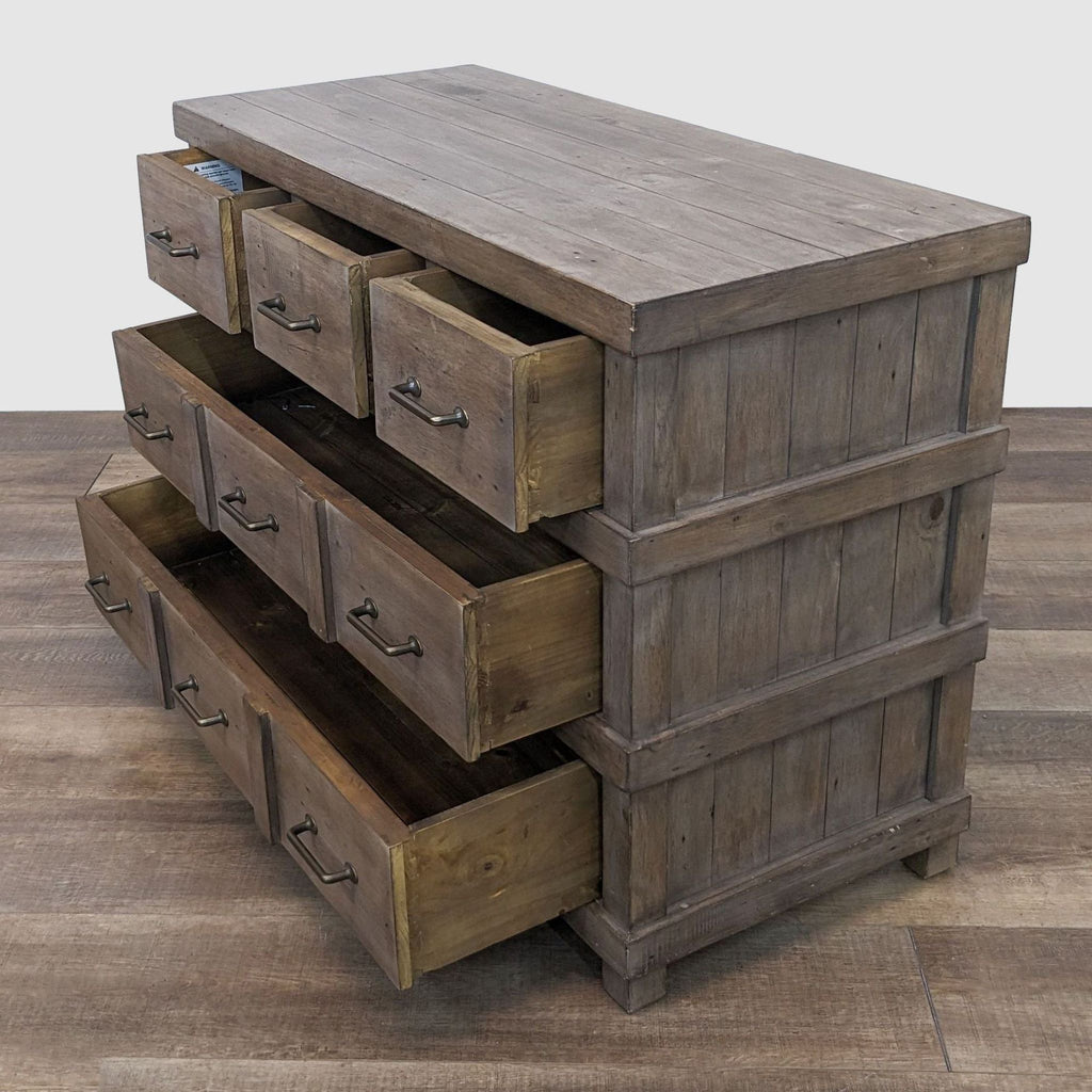 Side view of a wooden dresser with a weathered finish and open drawers.