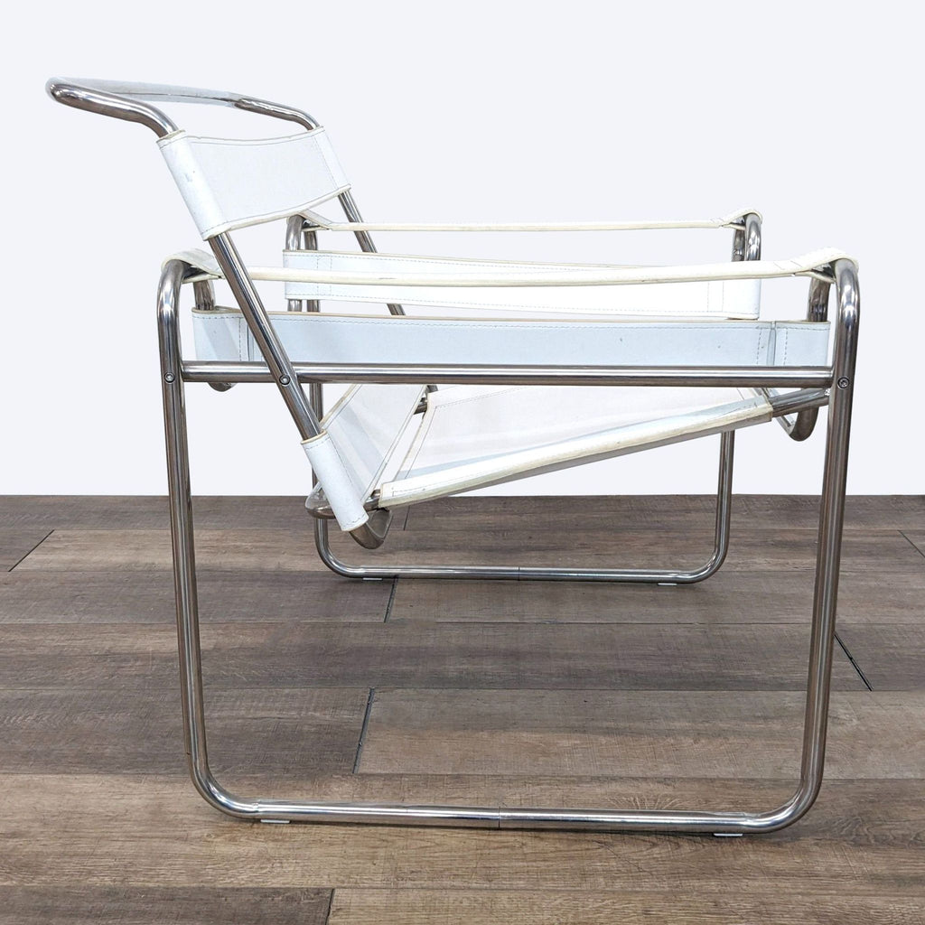2. Side angle of the Marcel Breuer-designed Wassily chair showing the chrome and leather structure on wooden flooring.