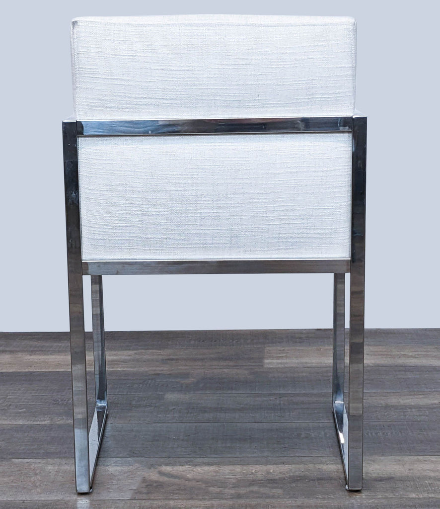 Back view of an ivory linen upholstered Reperch dining chair with a reflective stainless steel frame.