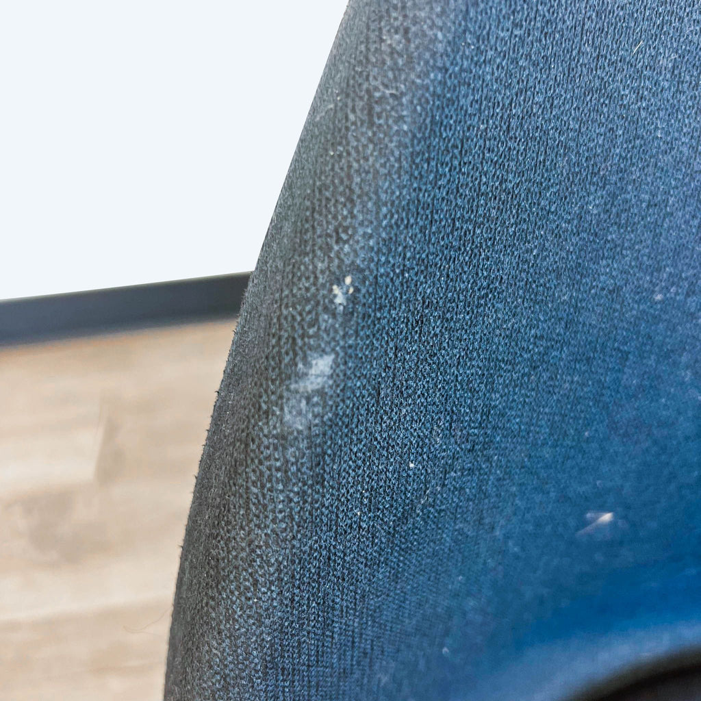 Close-up texture detail of IKEA Baltsar chair’s blue fabric upholstery and stitching.