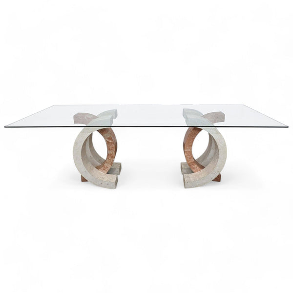 Rectangular glass-top Reperch dining table with unique fossil stone tile base on a wood floor.