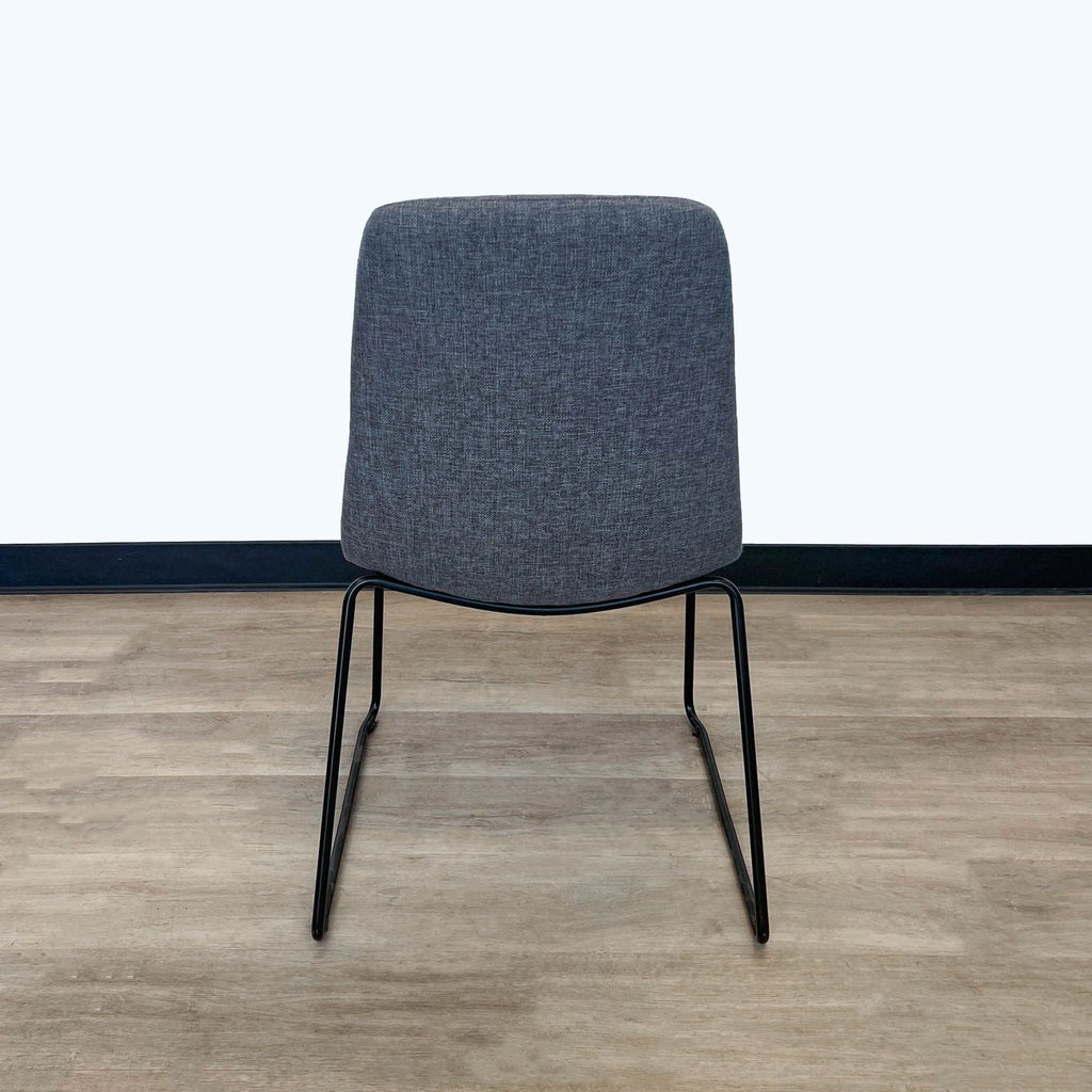 Durable grey fabric Reperch dining chair showcasing minimalist back design and slender legs, rear view.