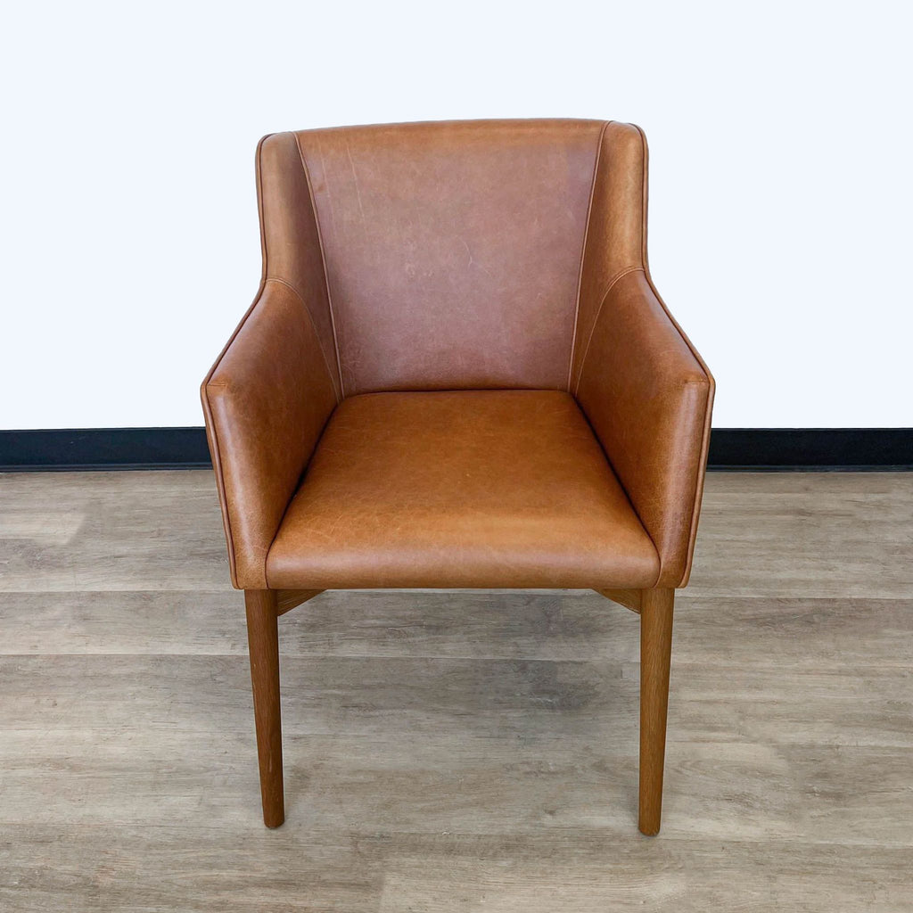 Square Roots Kepi brown leather lounge chair with sleek design, front view on a wood floor.