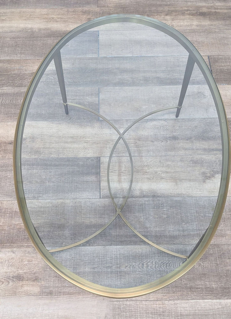 2. Top view of Thomas Pheasant coffee table, highlighting the brass frame and intersecting circular base design under the clear glass.