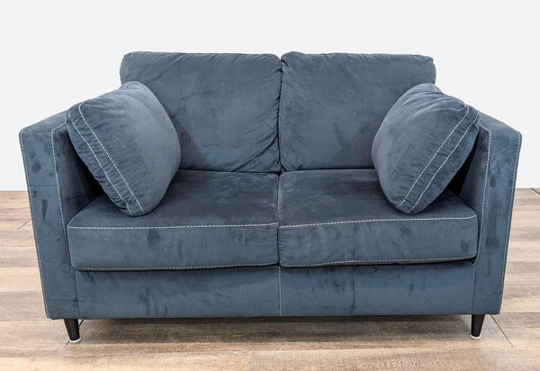 a blue sofa with a pair of matching cushions.