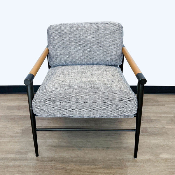 Front view of a Four Hands lounge chair with gray upholstery and wooden armrest accents on a black metal frame.