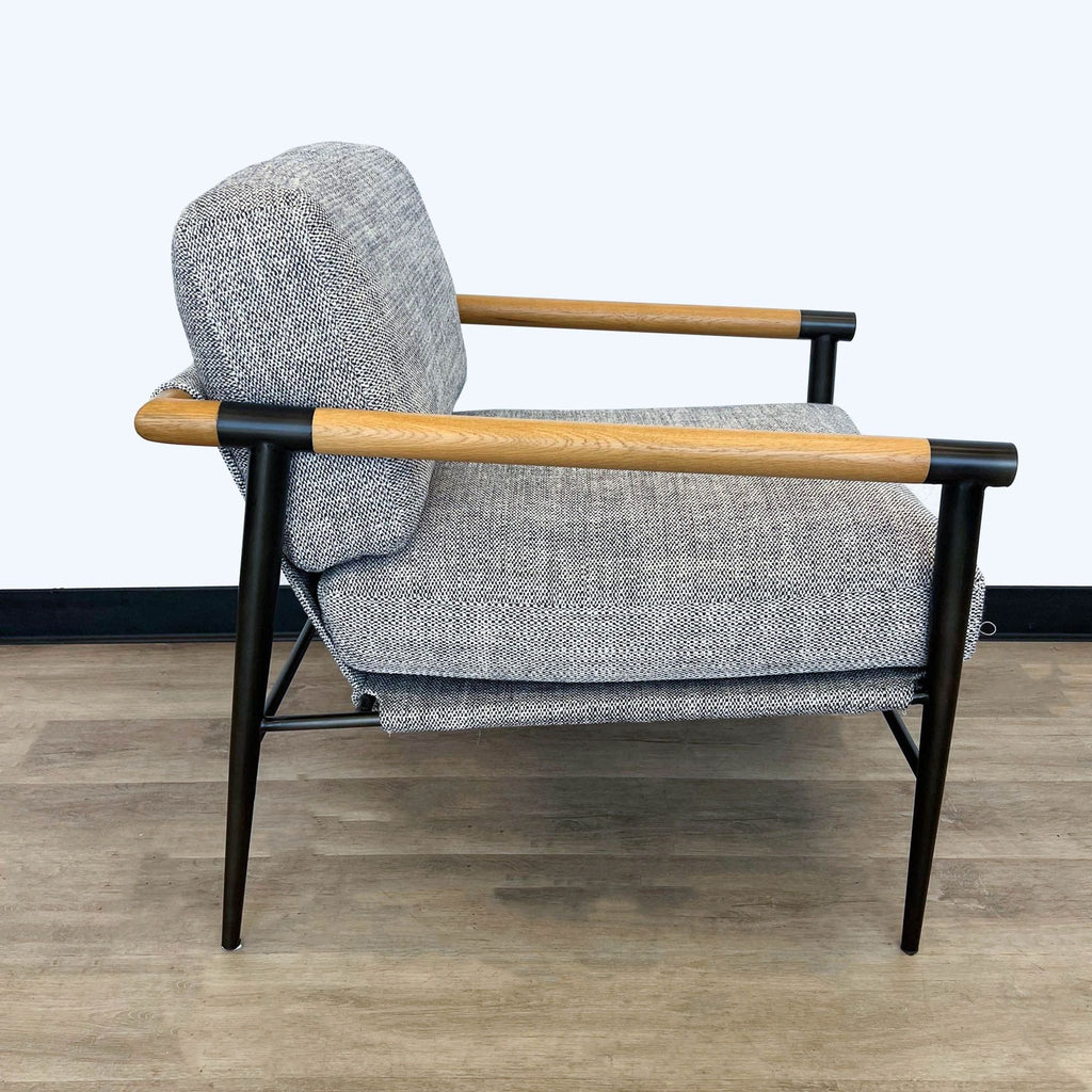 Side view of a Four Hands lounge chair showcasing its gray fabric and angular design with wooden armrests and metal legs.