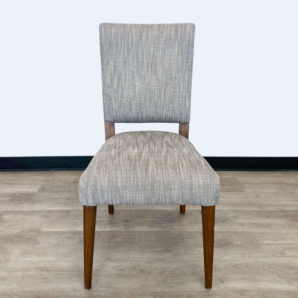 1. A front view of a mid-century-inspired Kurt dining chair by Four Hands with sepia-toned upholstery and pecan-finished birch legs.