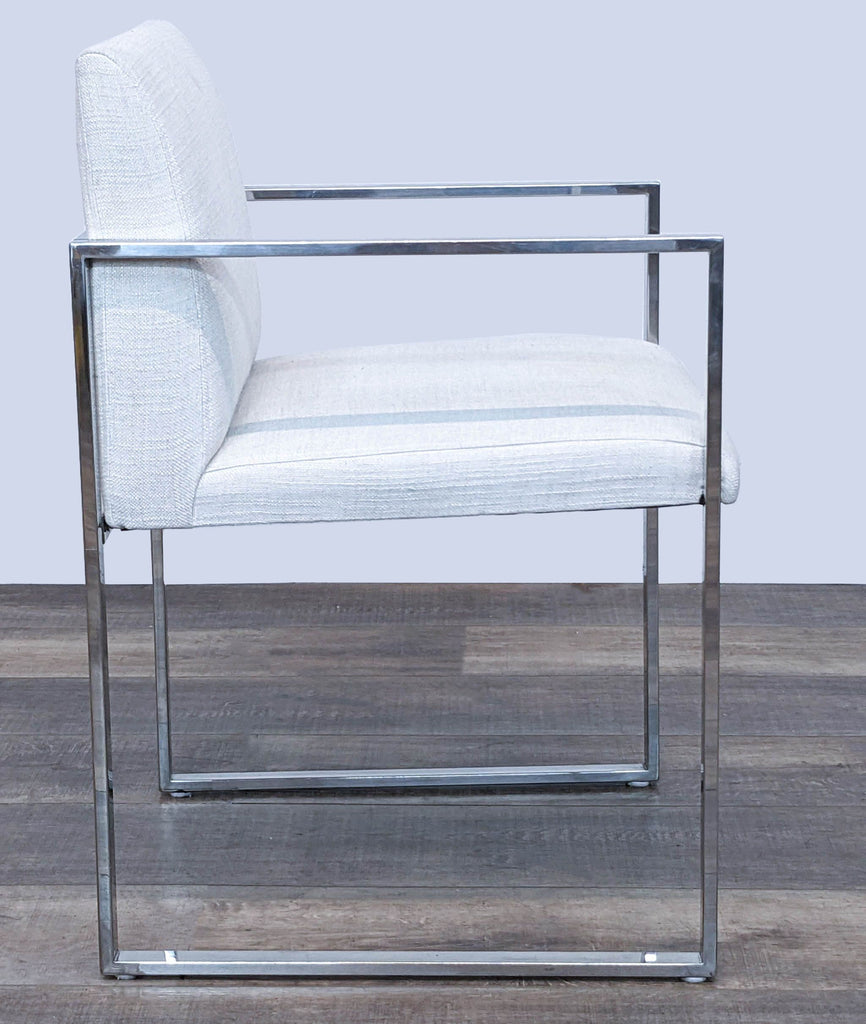 Modern side view of The Brownstone lounge chair featuring sleek lines, chrome frame, and light fabric.