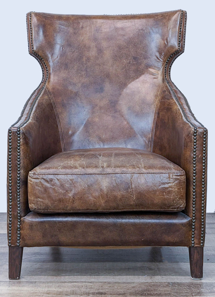 Front view of a Four Hands classic leather accent chair with high back and armrests, nailhead trim, and wood legs.