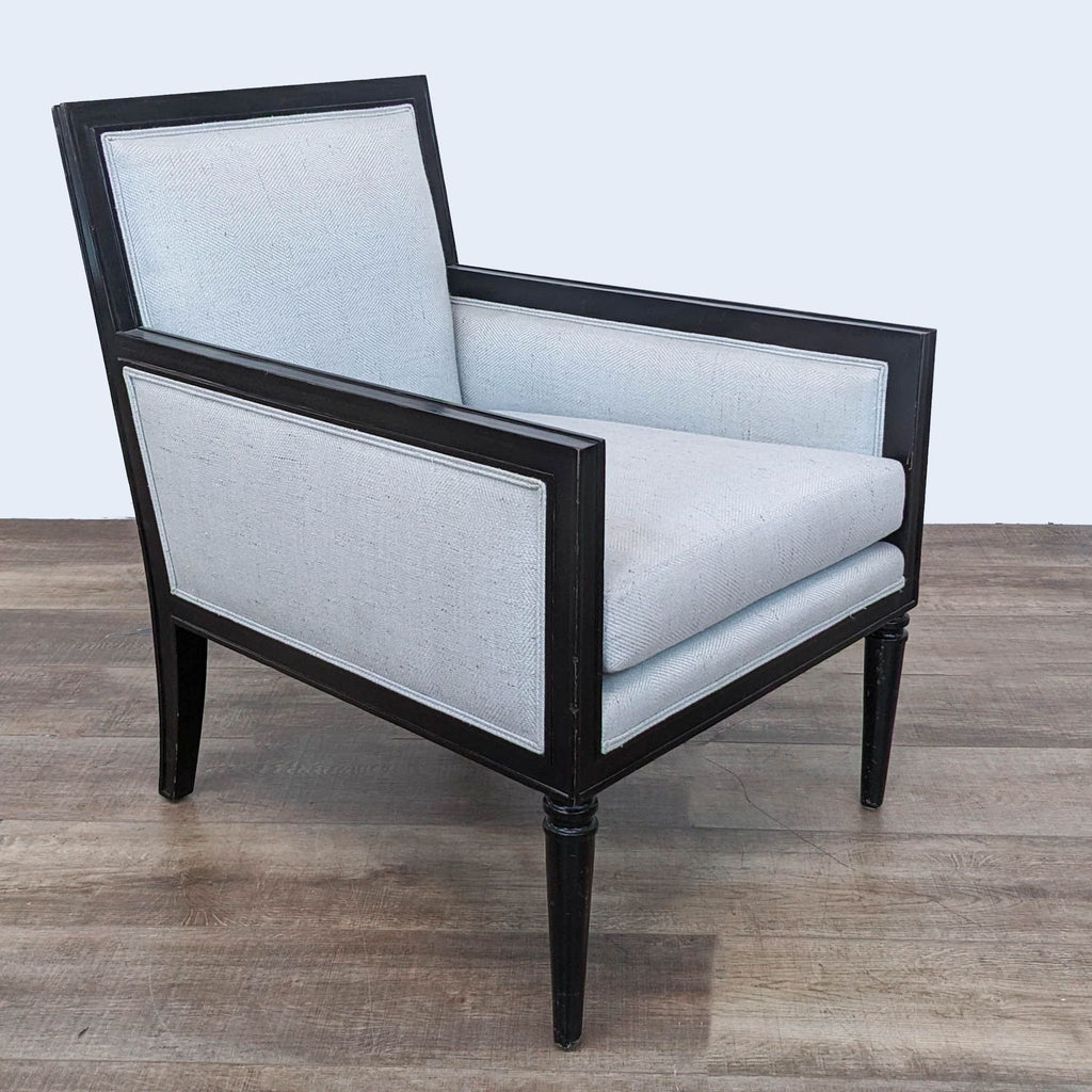 Angled view of sleek Reperch lounge chair with light fabric seat and black wooden legs.