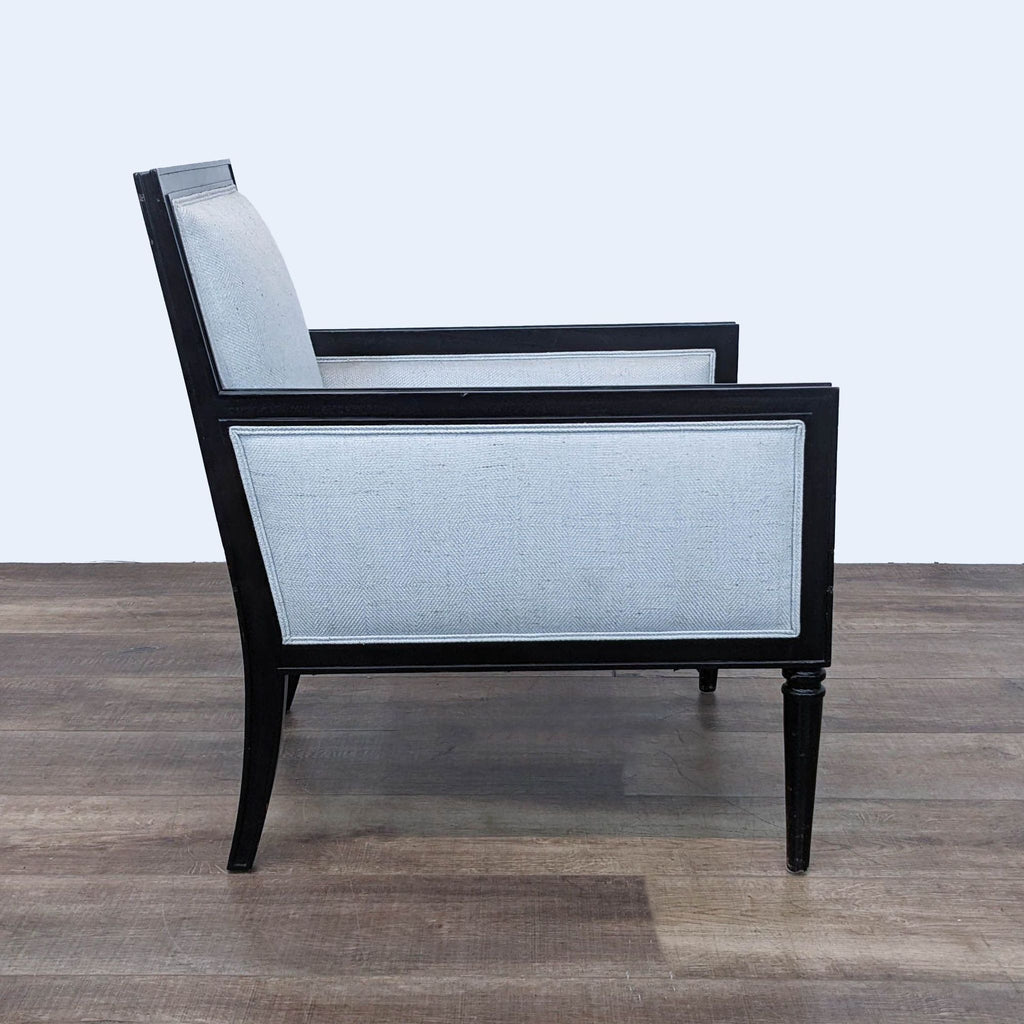 Side angle of Reperch lounge chair showcasing black wooden frame with textured cushion.