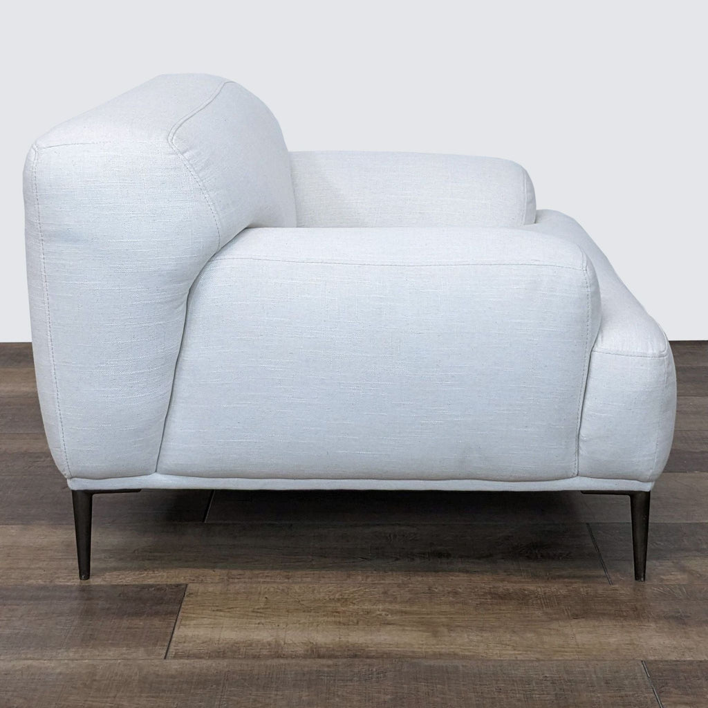 Side view of the Abisko chair by Article, showcasing titanium legs and cushioned armrest in Quartz White.