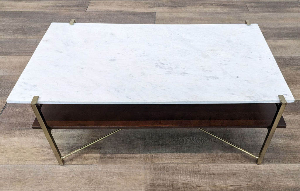 Contemporary coffee table with marble top, walnut oak shelf, set on brass legs from Anthropologie.