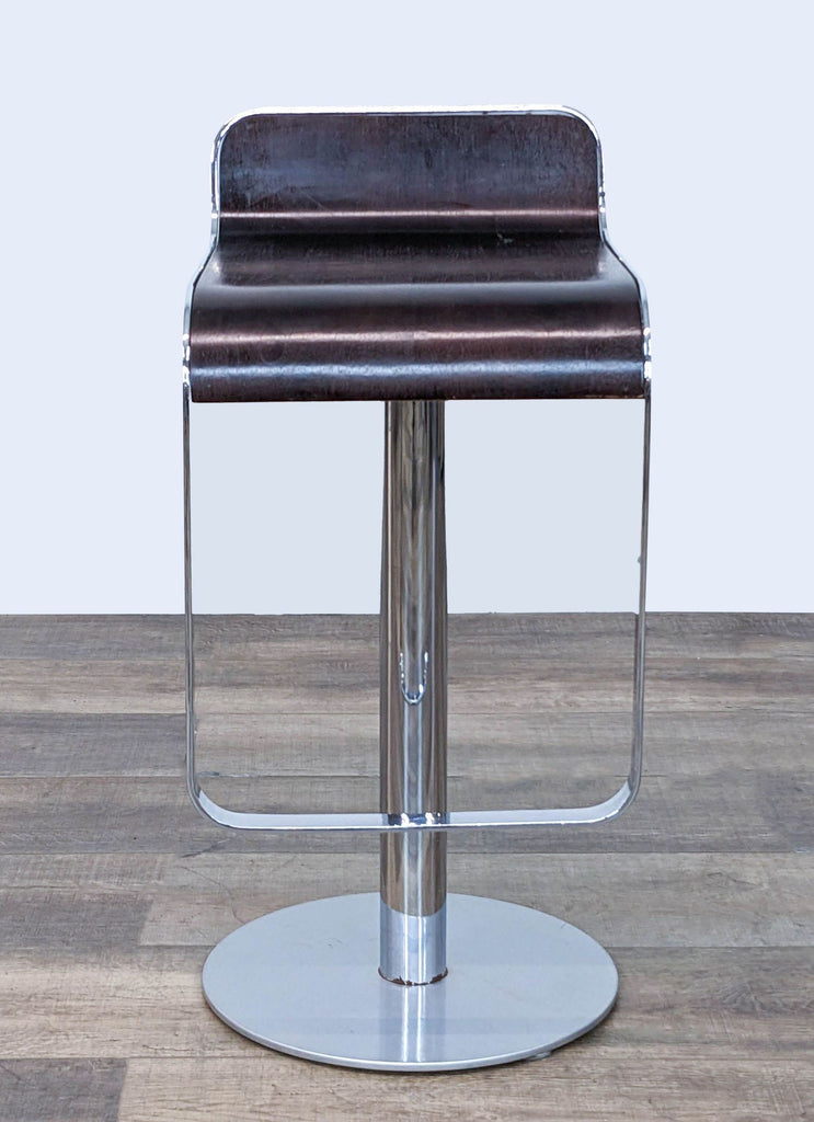 Dark wood veneer bar stool with chrome adjustable base and circular footrest, in modern style.  