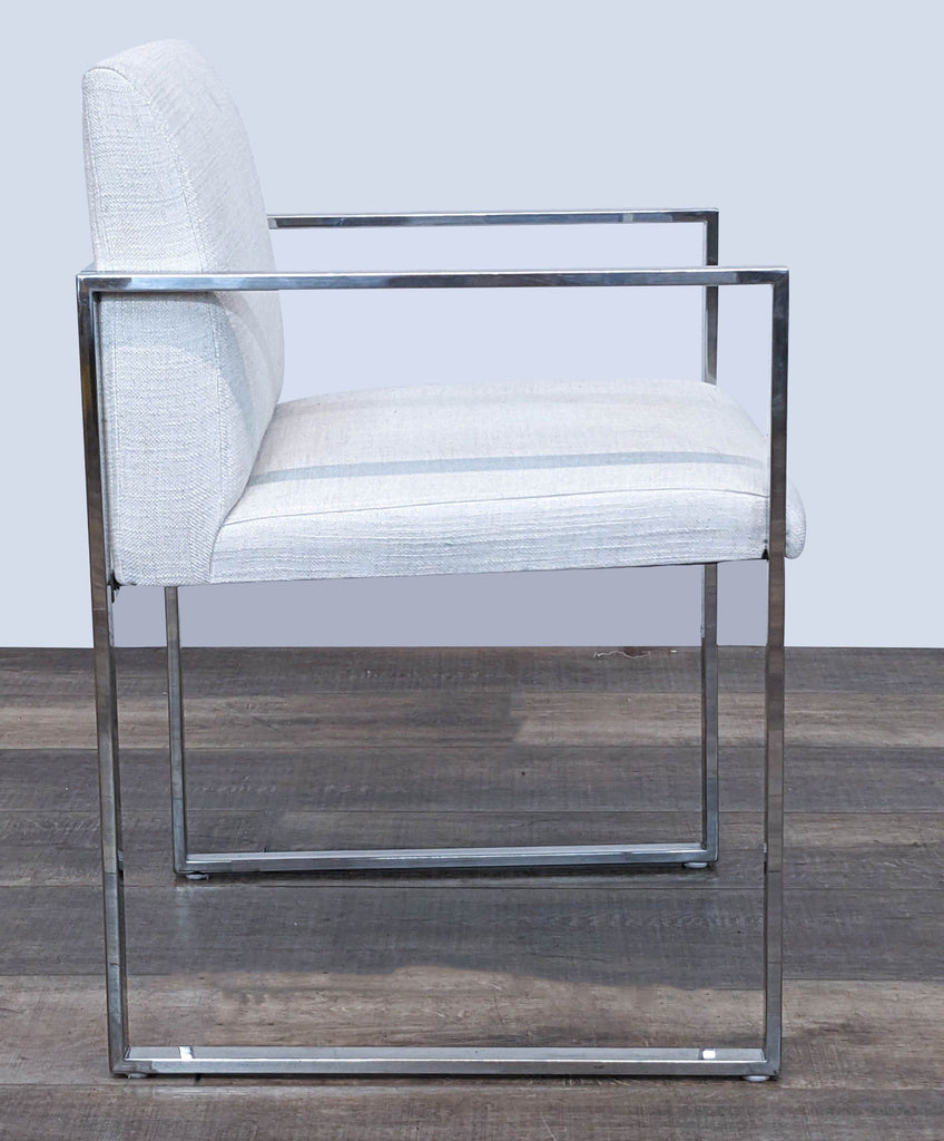 "Side view of The Brownstone modern dining chair, metal frame, with a soft upholstered seat in a lounge setting."