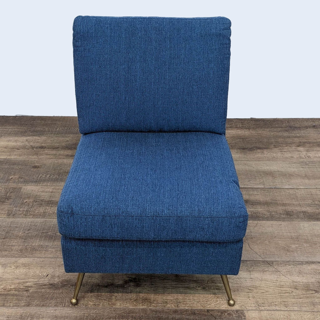 Frontal angle of a stylish Reperch navy blue lounge chair with a plush backrest and elegant golden legs on a wooden floor.