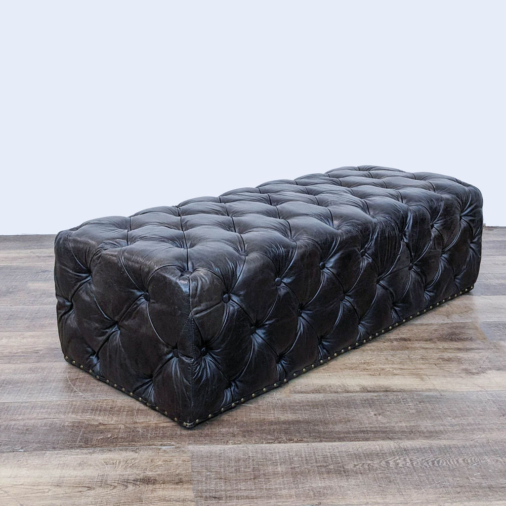 Elegant button-tufted ottoman featuring antique brass nailhead accents.