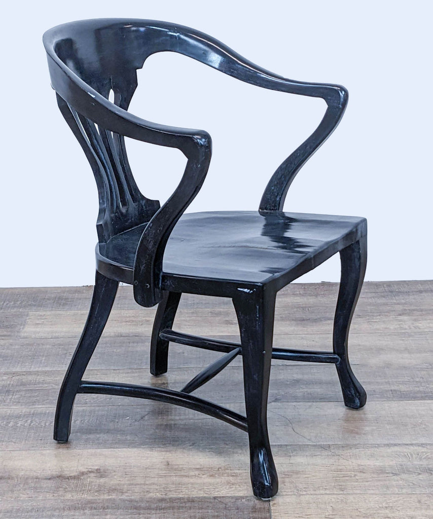 Elegant Reperch chair showcasing a curved backrest and armrests, black finish, side angle view on wooden floor.