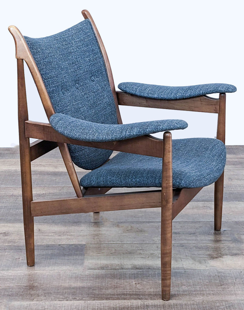 3. Three-quarter view of a McCreary Modern chair, displaying its inviting curves and comfortable blue fabric cushions.